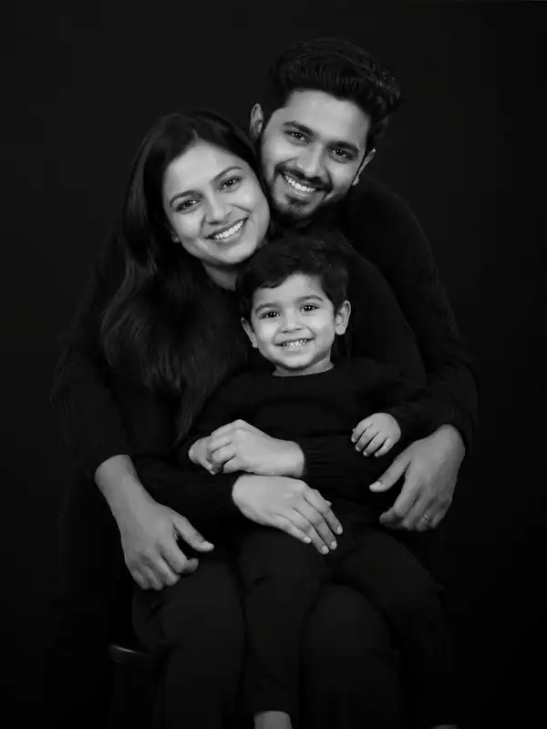 chatgpt family photo prompt seated family portrait.webp ChatGPT family photo prompt showing an Indian family of three seated together in a close black-and-white studio portrait