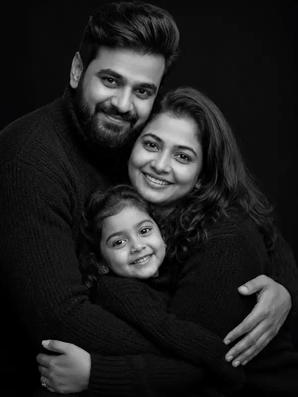 chatgpt family photo prompt timeless family hug.webp ChatGPT family photo prompt showing an Indian family of three sharing a close hug in a black-and-white studio portrait